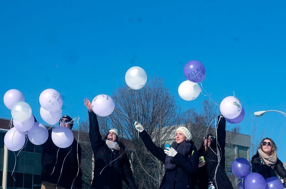 <p>From left, Spartans Fighting for Cancer club members microbiology senior Adam Matynowski, supply chain management senior Lauren Murphy, nursing junior Kaitlin Aldea, social work senior Sarah Hoffman, and nutritional science junior Jenna Chaffee release balloons Feb. 5, 2015, at The Rock on Farm Lane in memory of survivors and current fighters of cancer. The balloon release was just one of the events the club has been doing all week in preparation for their big kickoff event on Feb. 8 at noon in the Wharton Center. Camille Douglas/The State News</p>