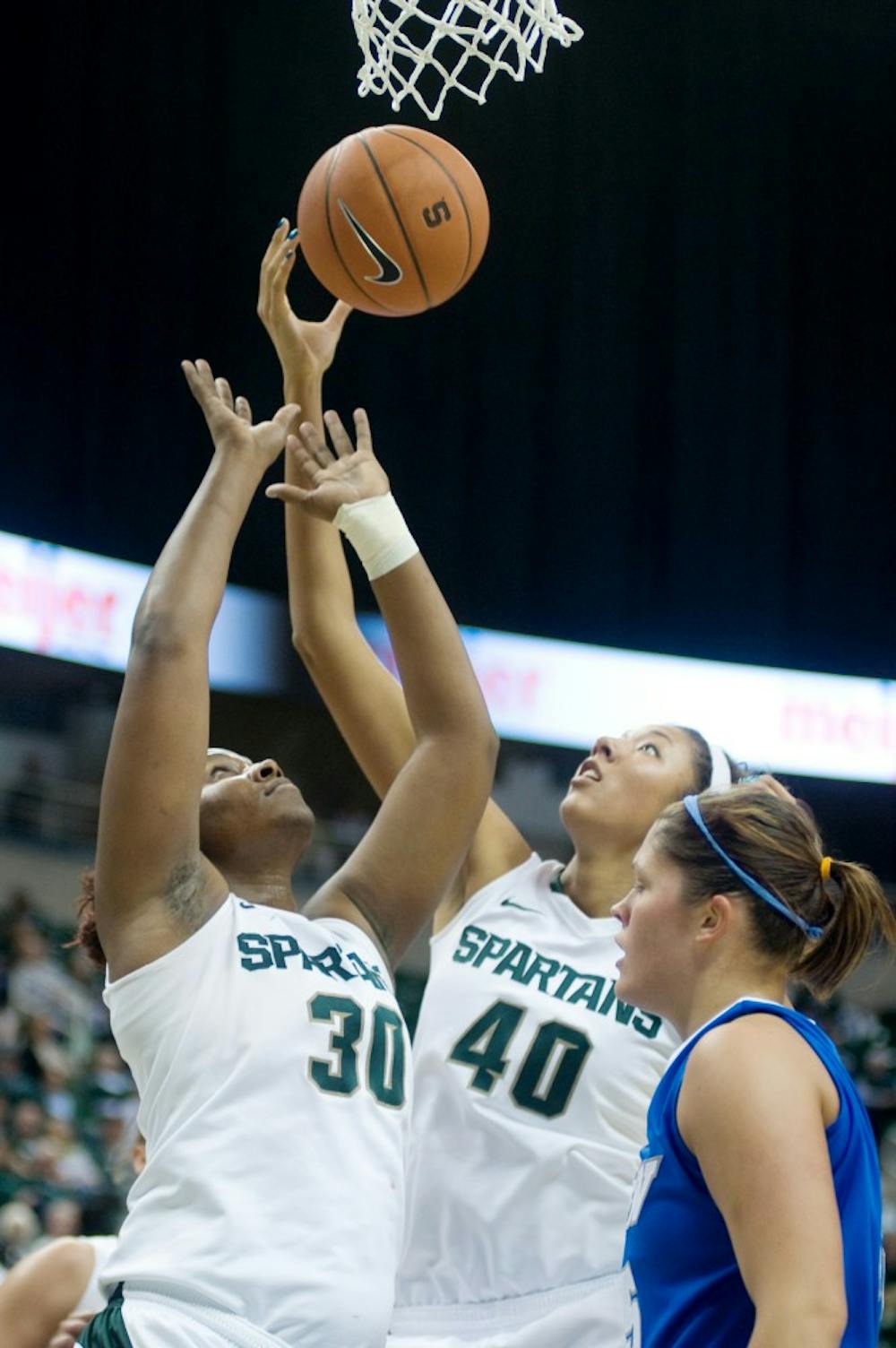 Senior forward Lykendra Johnson and red-shirt freshman forward Madison Williams both go up for a rebound during the first half of Tuesday's game at Breslin Center. Lauren Wood/The State News