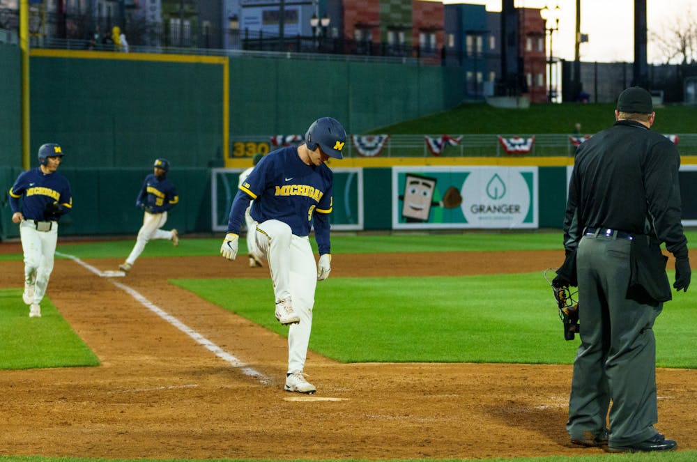 <p>Michigan sophomore Dylan Stanton (9) stomps on home with sophomore Brandon Lawrence (4) right behind him and junior right fielder Clark Elliott (15) right behind them, after Elliott scored a home run in the ninth inning. Michigan State lost 18-6 to Michigan on April 15, 2022 at the Lugnut Stadium.</p>
