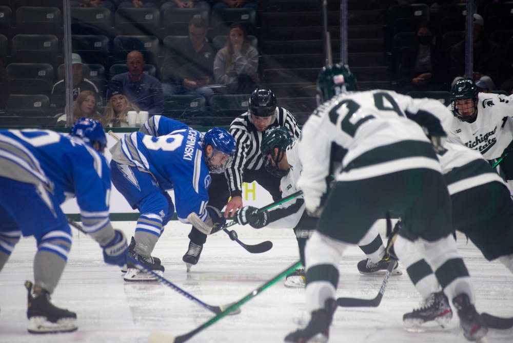 The referee throws down the puck during Michigan State's loss to Air Force on Oct. 8, 2021.