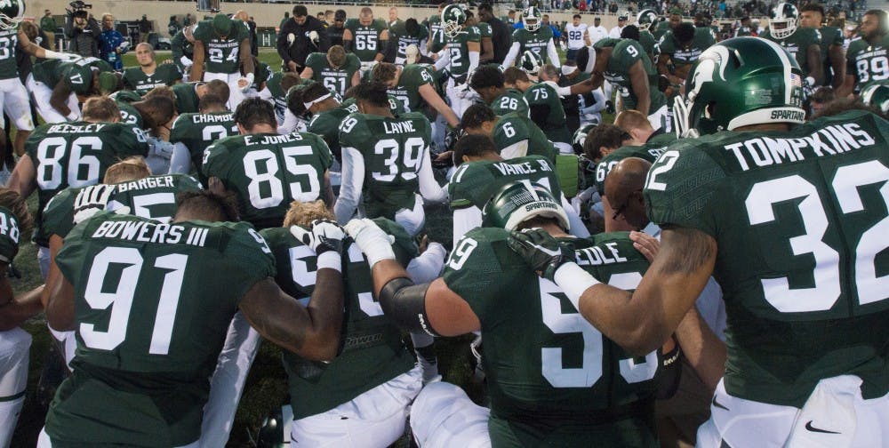 The Spartans take a knee in the center of the field to honor former cornerback Mylan Hicks (6) after the game against Brigham Young University on Oct. 8, 2016 at Spartan Stadium.  Hicks played from 2010-14 and died unexpectedly in late September.