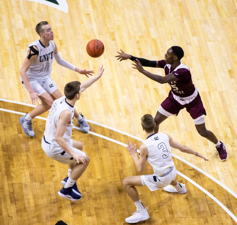 Senior guard Kamal Hadden passes through three defenders in the MHSAA Division 2 boys basketball finals March 16, 2019, at Breslin Center. The Unity Christian Crusaders defeated the River Rouge Panthers, 58-55.