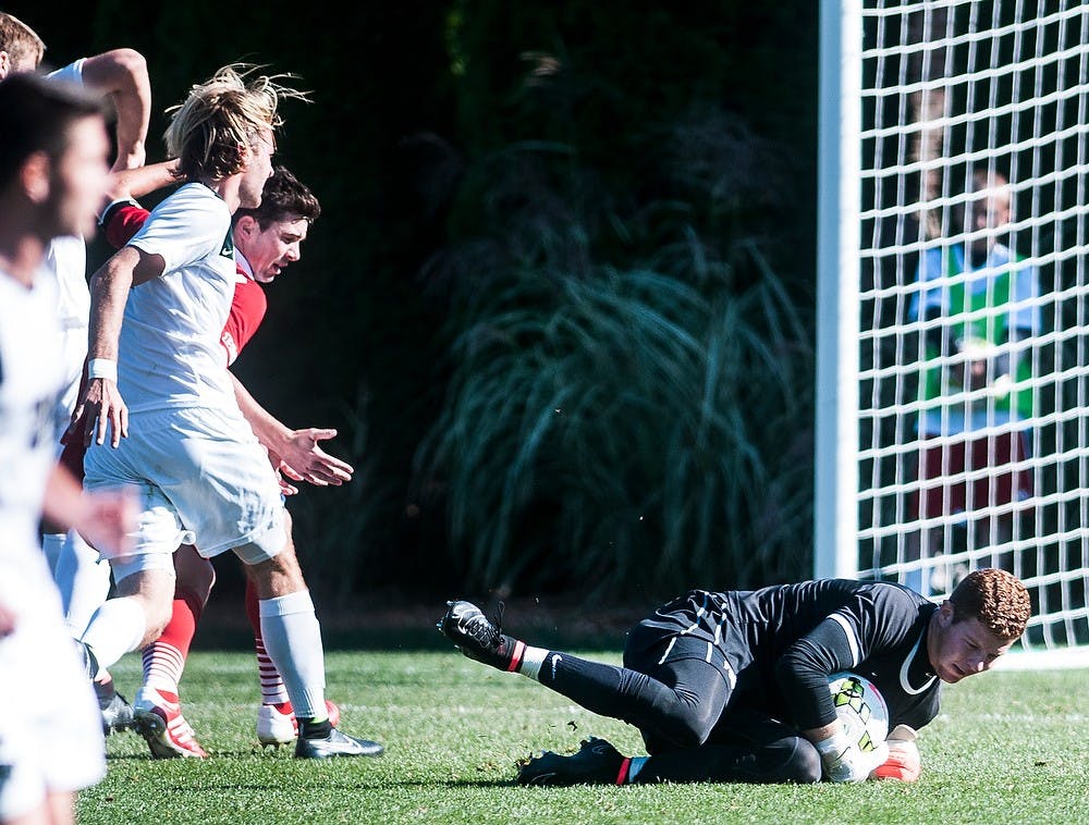 <p>Junior goalkeeper Zach Bennett saves the ball Oct. 11, 2014, during a game against Wisconsin at DeMartin Soccer Stadium at Old College Field. The Spartans defeated the Badgers, 2-1. Erin Hampton/The State News</p>