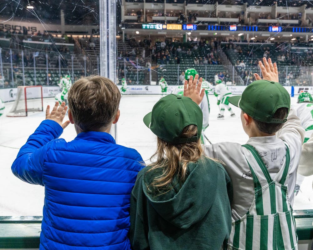 Young MSU fans support MSU and bang on the glass before the game in Munn Ice Arena in East Lansing, MI on Feb. 19. 2026.
