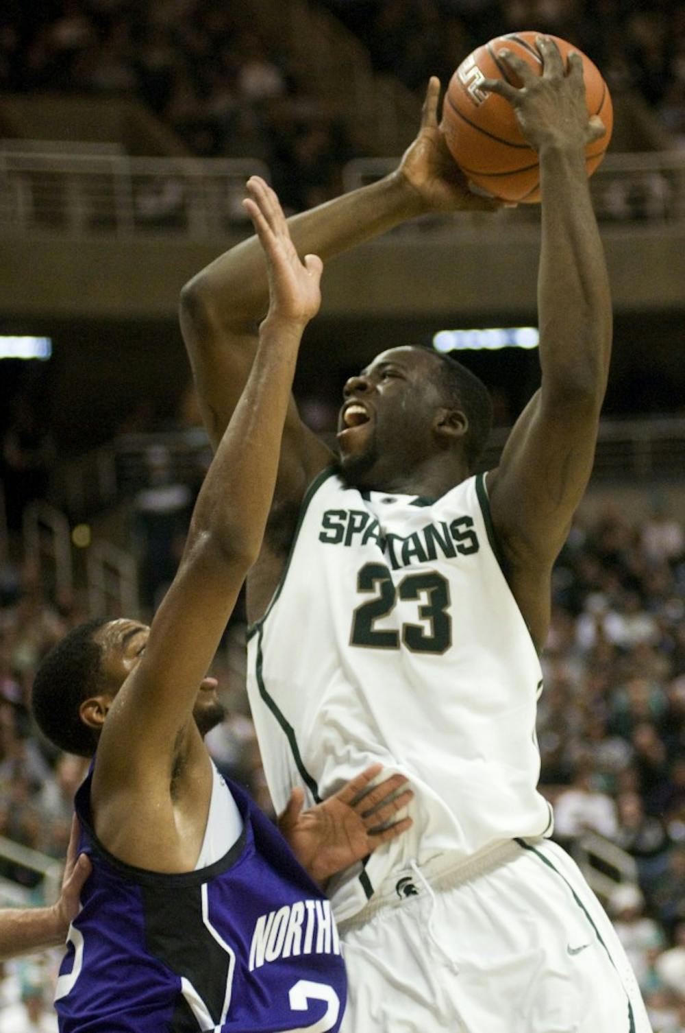 Junior forward Draymond Green goes up for a shot against Northwestern guard Michael Thompson in the second half of Saturday's game at Breslin Center. Green scored 16 total points, lifting the Spartans to a 71-67 win over the Wildcats in overtime. Lauren Wood/The State News