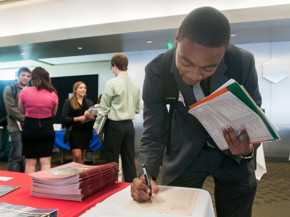 Food industry management senior Shaka Dukes signs up to recieve information from the University of Wisconsin during a law fair at the Huntington Club in Spartan Stadium on Wednesday, Sept. 19, 2012. Dukes said he wants to go into corporate law. Julia Nagy/The State News