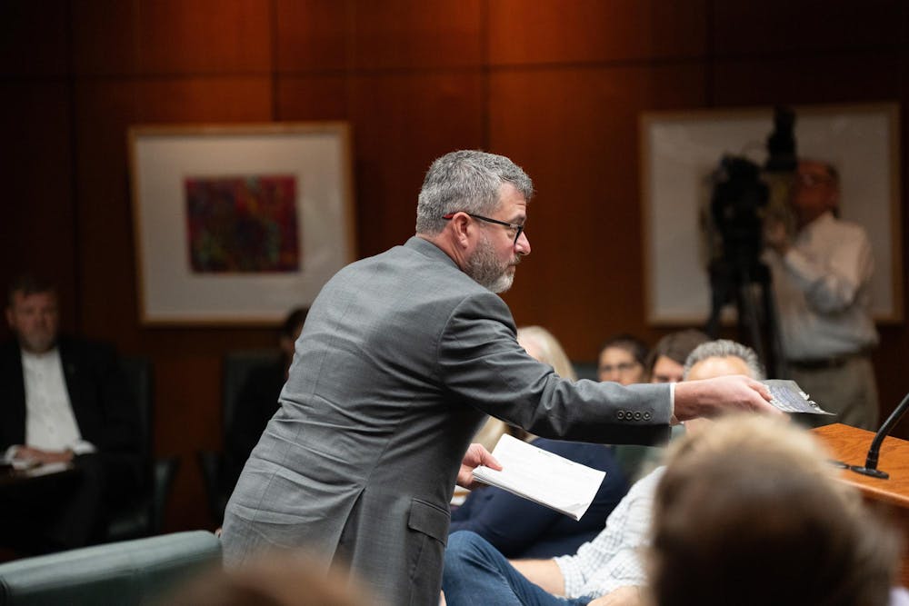 Vice President for Legal Affairs and General Counsel Brian Quinn, being handed a lawsuit from a Sister Survivor member at the Board of Trustees Meeting at the Hannah Administration Meeting on Sep. 8, 2023.
