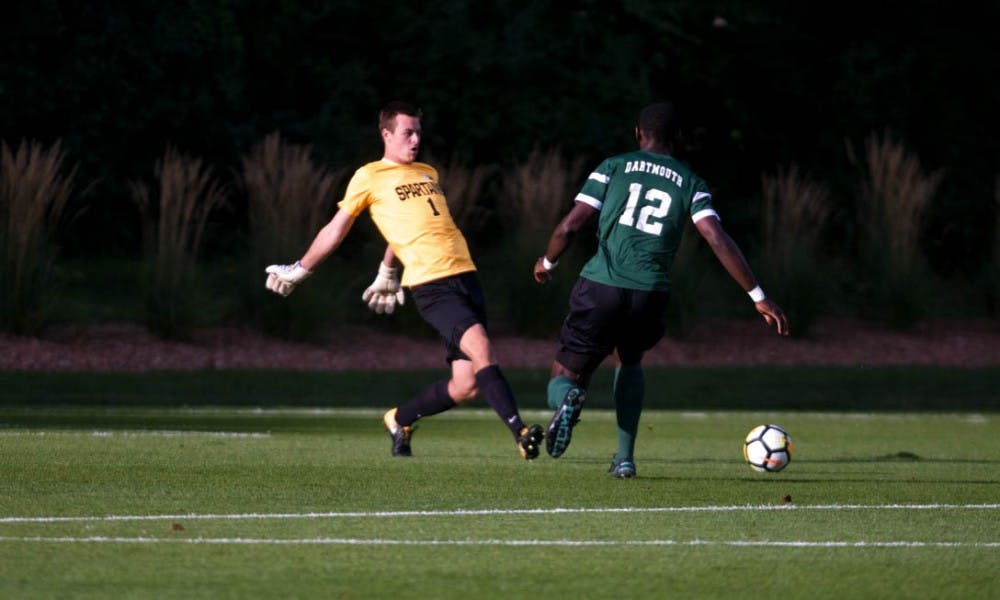 <p>Senior goalkeeper Jimmy Hague (1) beats out Dartmouth forward Eduvie Iboka (12) during a game against Dartmouth on Sep. 1, 2017 at DeMartin Stadium at Old College Field. The Spartans defeated the Big Greens 1-0.</p>