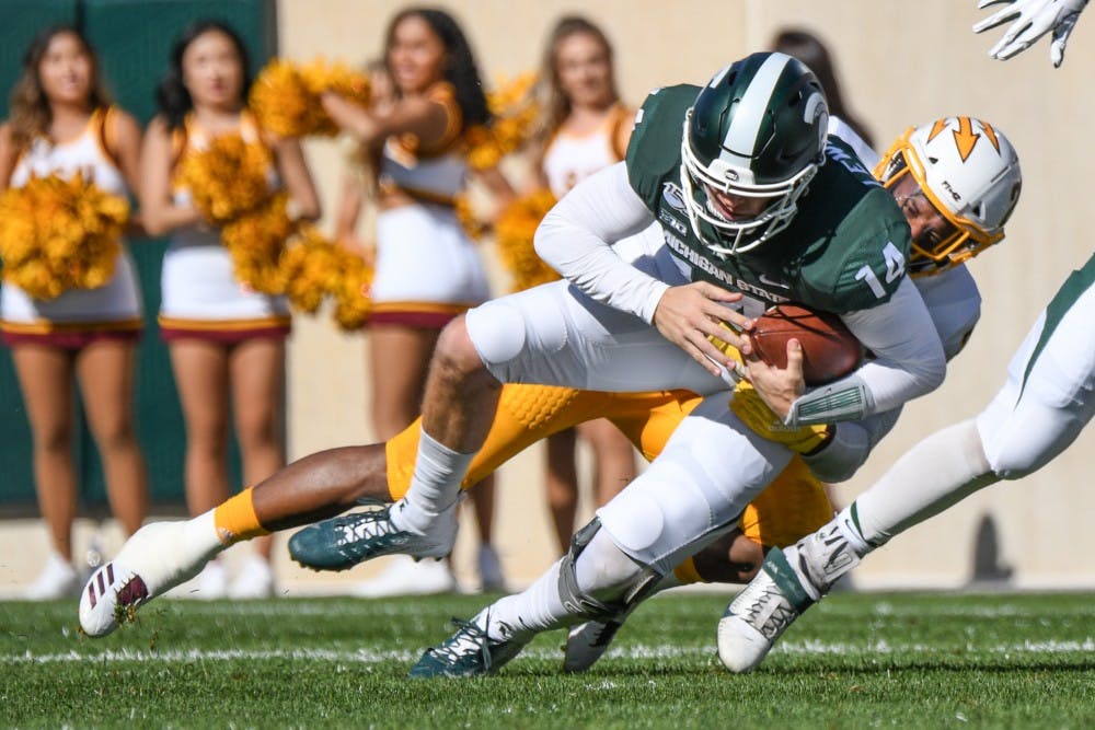<p>Redshirt senior quarterback Brian Lewerke (14) scrambles during the game against Arizona State on Sept. 14, 2019 at Spartan Stadium. The Spartans fell to the Sun Devils, 10-7.</p>