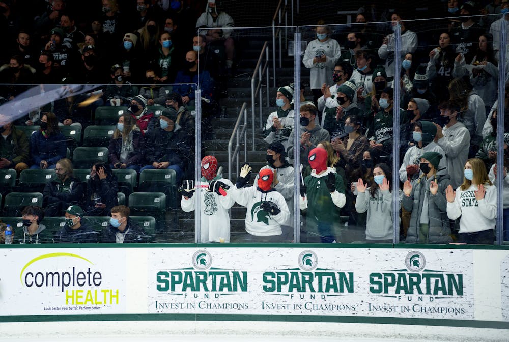 <p>Three members of the Michigan State hockey student section briefly wear Spiderman masks during the Michigan State vs Notre Dame game on Feb. 19, 2022. Spartans lost 4-2 against Notre Dame.</p>
