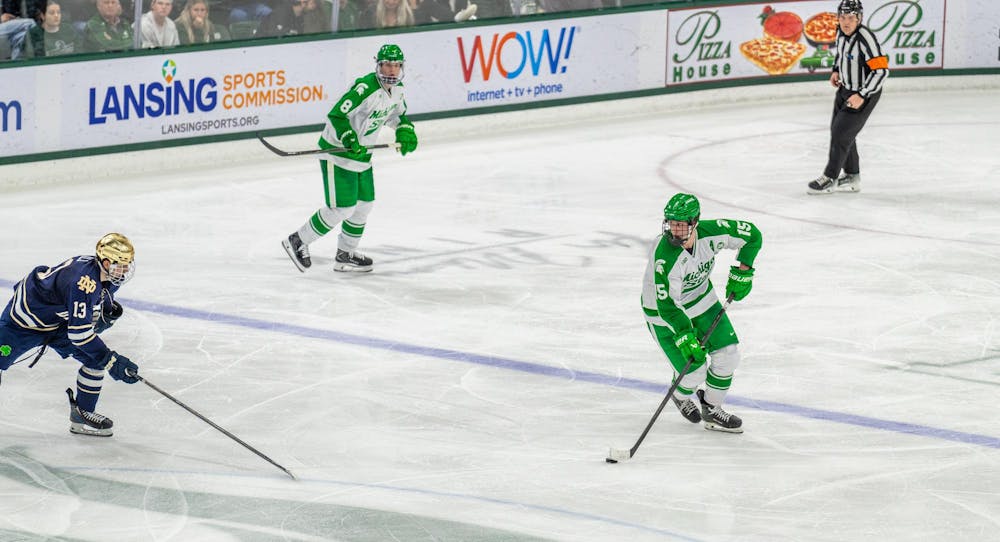 MSU Sr. F, Charlie Stramel (15), keeps the puck away from a Notre Dame player in Munn Ice Arena in East Lansing, MI on Feb. 19, 2026.