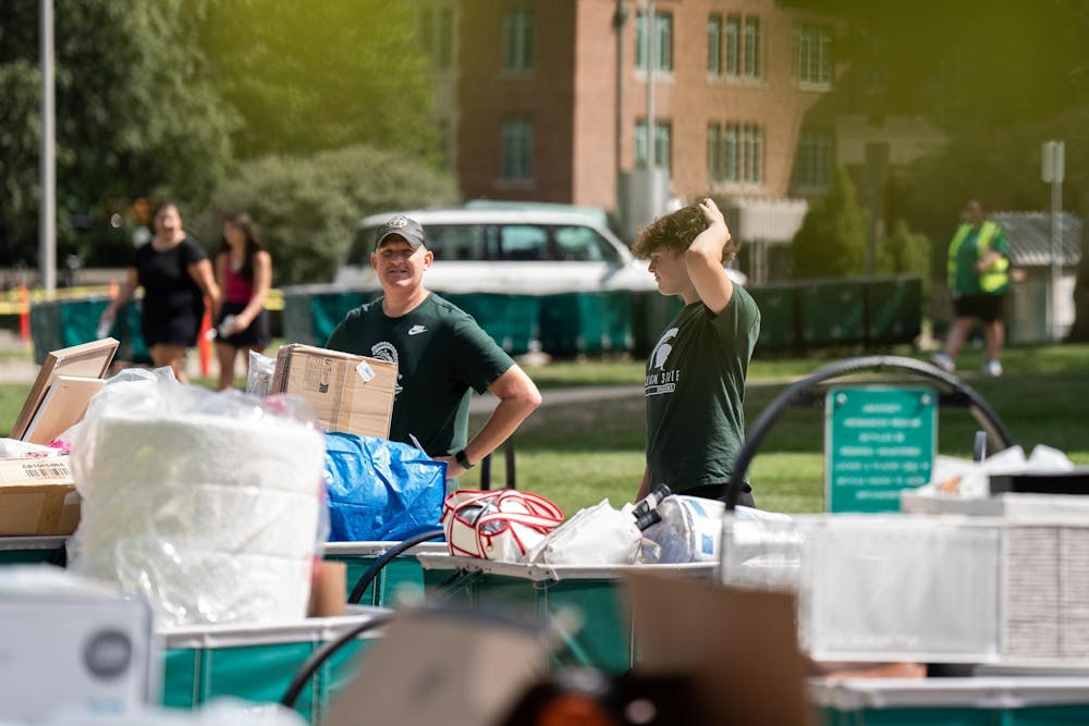 <p>An MSU student and his family member gather with their move-in carts, awaiting their turn to bring items into their room during fall move-in at Yakeley Hall in East Lansing, Mich., on Aug. 25, 2026.</p>