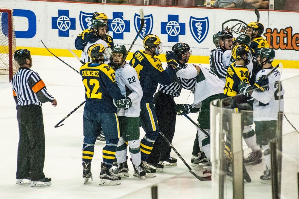 The Spartans and Wolverines argue with one another during the first period of the 52nd Annual Great Lakes Invitational third-place game against the University of Michigan on Dec. 30, 2016 at Joe Louis Arena in Detroit. The Spartans were defeated by the Wolverines in overtime, 5-4.