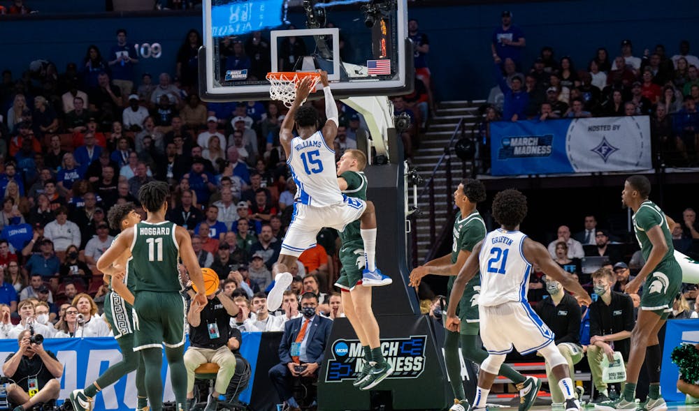 <p>Sophomore center Mark Williams (15) hangs onto the rim after dunking during Duke&#x27;s victory over Michigan State on March 20, 2022.</p>