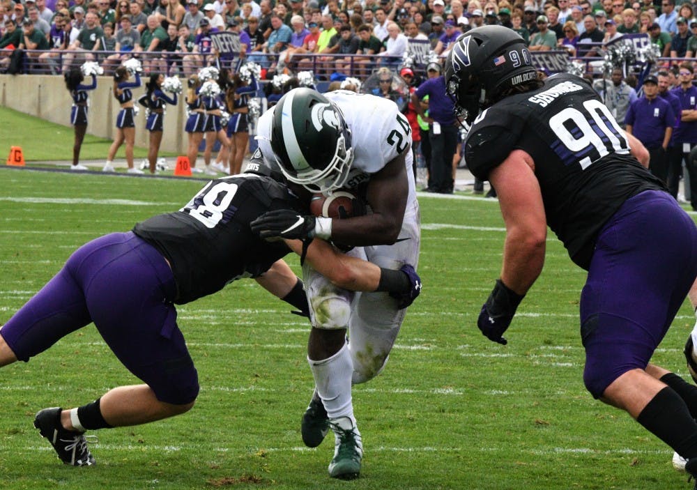 <p>Redshirt freshman running back Elijah Collins (24) gets tackled during the game against Northwestern at Ryan field on Sept. 21, 2019. MSU defeated Northwestern 31-10.</p>