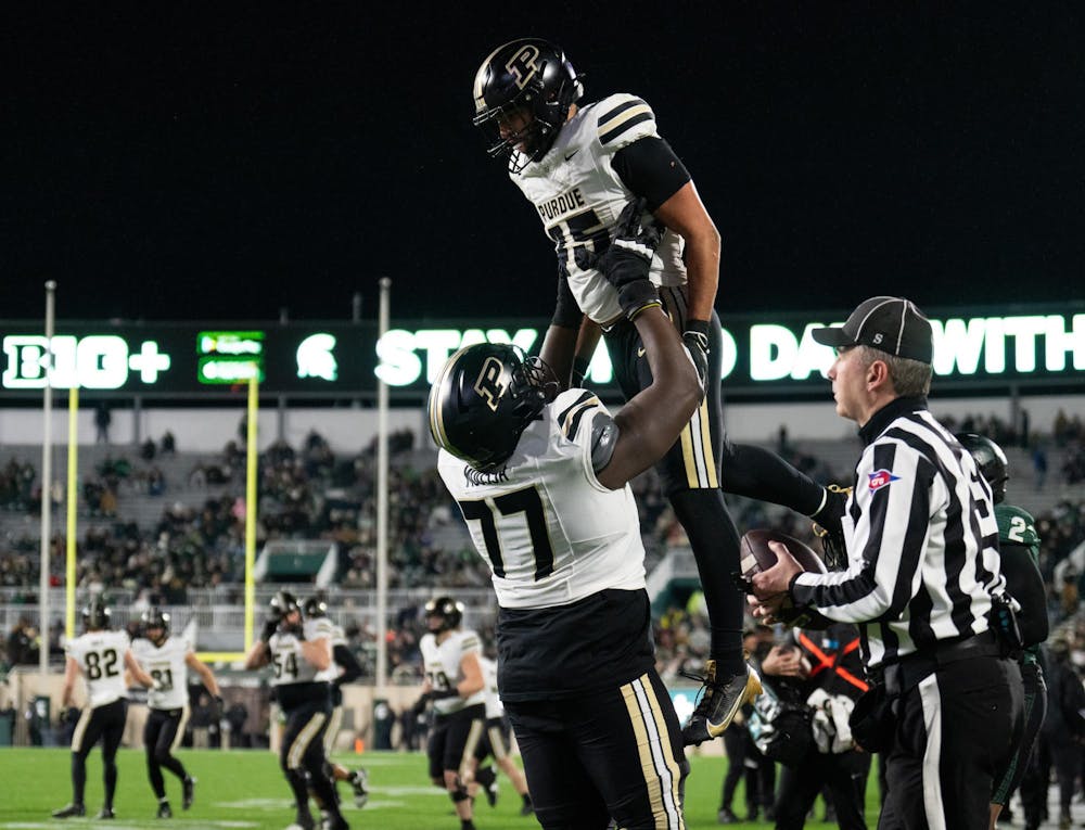 <p>Purdue junior offensive lineman Mahamane Moussa (77) lifts junior running back Devin Mockobee (45) in celebration after a touchdown at Spartan Stadium on Nov. 22, 2024.</p>