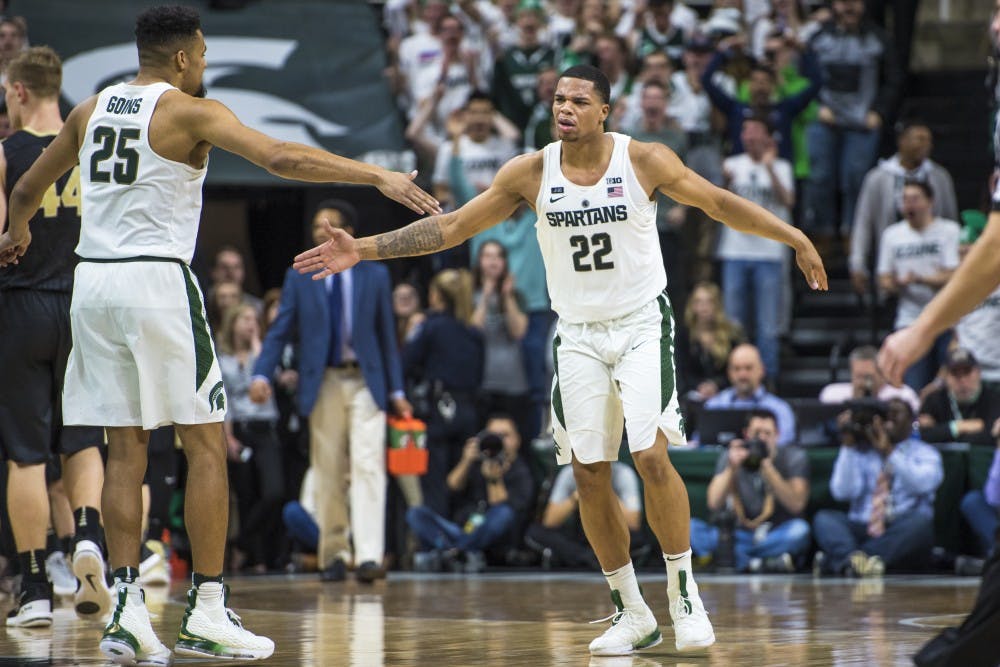 Sophomore guard Miles Bridges (22) goes to slap hands with junior forward Kenny Goins (25) during the second half of the men's basketball game against Purdue on Feb. 10, 2018 at Breslin Center. The Spartans defeated the Boilermakers, 68-65. (Nic Antaya | The State News)