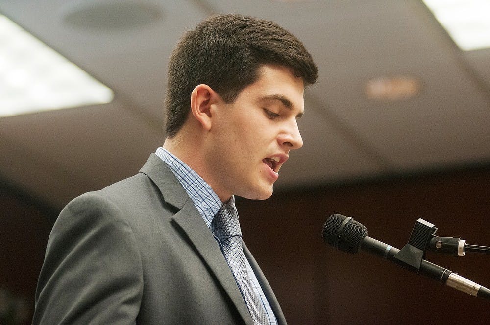	<p>Social relations and policy senior Michael Mozina stands to represent <span class="caps">ASMSU</span> in front of the board of trustees, June 21, 2013, in the Administration Building board room. <span class="caps">ASMSU</span> members gathered at the meeting to protest against the administration&#8217;s actions towards the association. Danyelle Morrow/The State News</p>