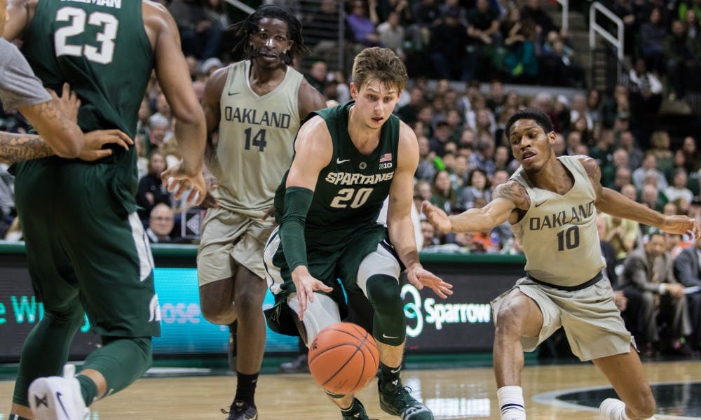 Senior guard Matt McQuaid (20) dribbles the ball during the game against Oakland University at Breslin Center on Dec. 21, 2018. The Spartans defeated the Grizzlies, 99-69.