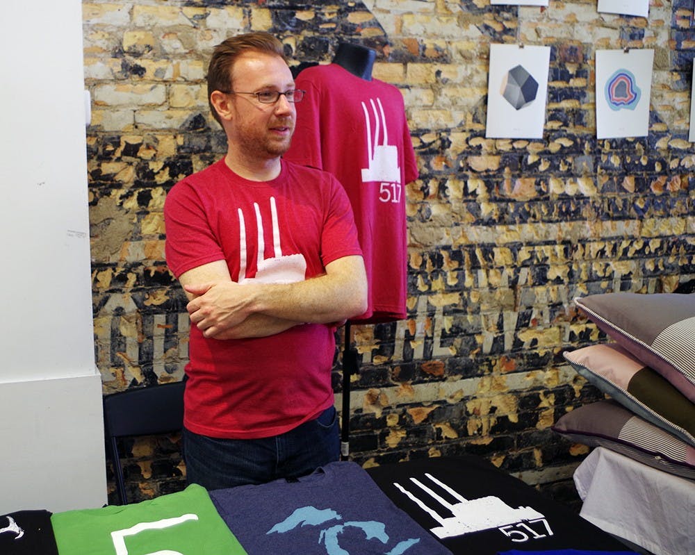 <p>Ty Forquer, the owner of 517 Shirts, talks with a customer at River City MRKT June 6, 2015, in REO Town, Lansing. 517 shirts represent Lansing and Michigan in their designs. Yuanzhe Zhuang/The State News</p>