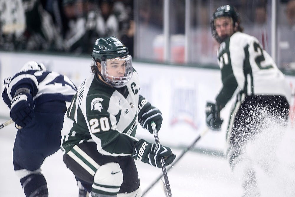 <p>Junior forward Michael Ferrantino skates to a stop to get the puck as sophomore forward Joe Cox and Penn State forward Casey Bailey skate back toward MSU's goal Feb. 13, 2015, at Munn Arena. The Spartans defeated Penn State, 3-0. They will play each other again Feb. 14, 2015. Allyson Telgenhof/The State News.</p>