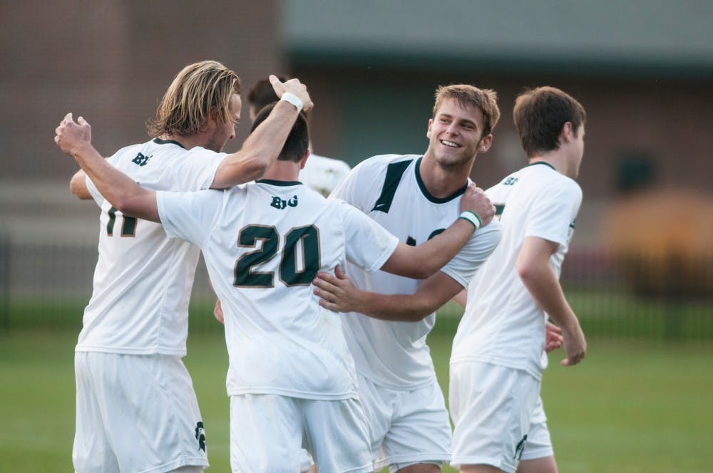 <p>Senior defender Ryan Keener and junior midfielder Jason Stacy celebrate with junior defender Zach Carroll after a goal is made on Oct. 15, 2014, at DeMartin Soccer Stadium at Old College Field. The Spartans defeated the Broncos, 4-0. Aerika Williams/The State News</p>