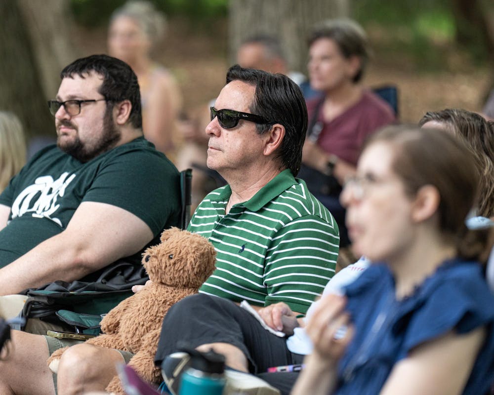 <p>An attendee of the Music and the Garden event at the W.J. Beal Botanical Garden sits with a teddy bear on their lap while listening to the Go Music Trio perform in East Lansing, Mich., on June 28, 2026.</p>