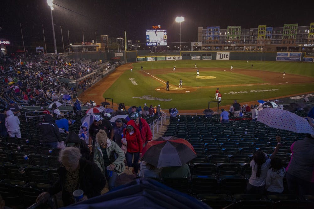 Baseball fans take cover from the brief rain shower during the 13th Annual Crosstown Showdown on Sept. 3, 2019 at Cooley Stadium in Lansing. The Lugnuts defeated the Spartans, 5-1. 