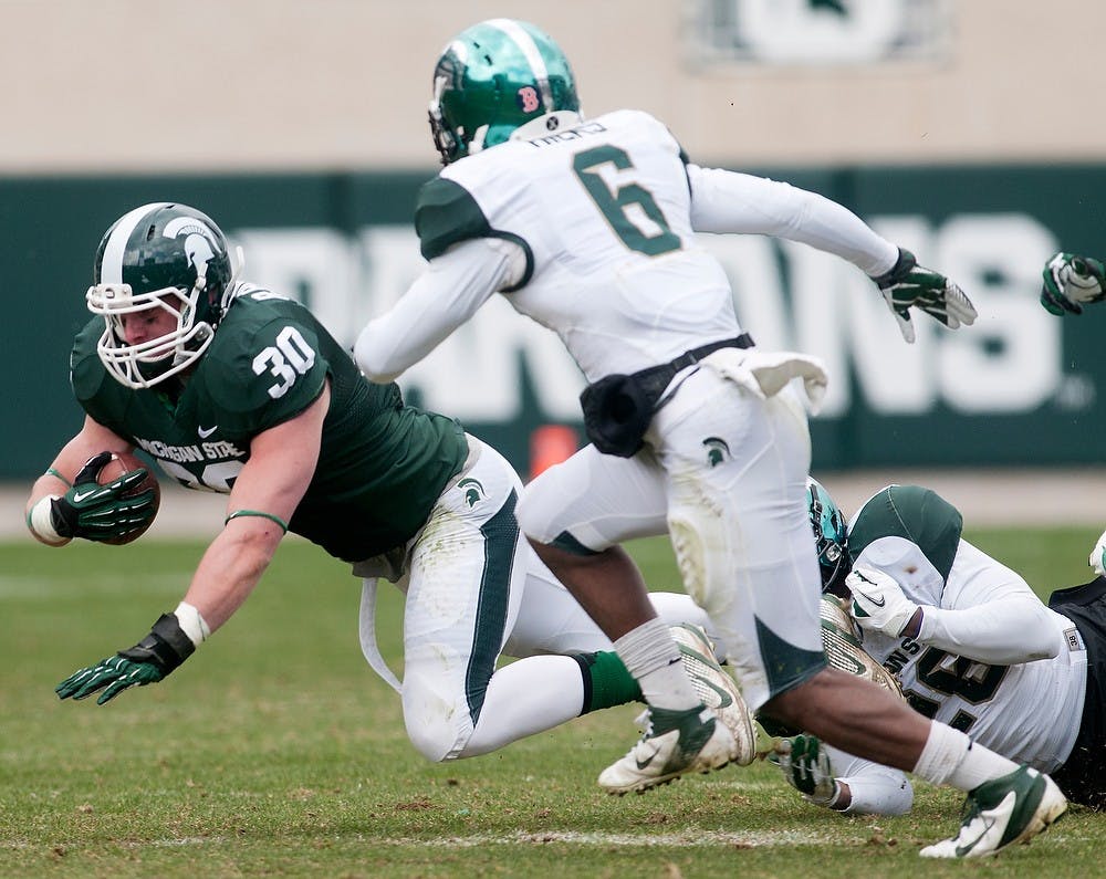 	<p>Freshman running back/linebacker Riley Bullough is tackled by sophomore safety R.J. Williamson, 26, during the Green and White Spring Game on April 20, 2013, at Spartan Stadium. The White team won 24-17. Julia Nagy/The State News</p>