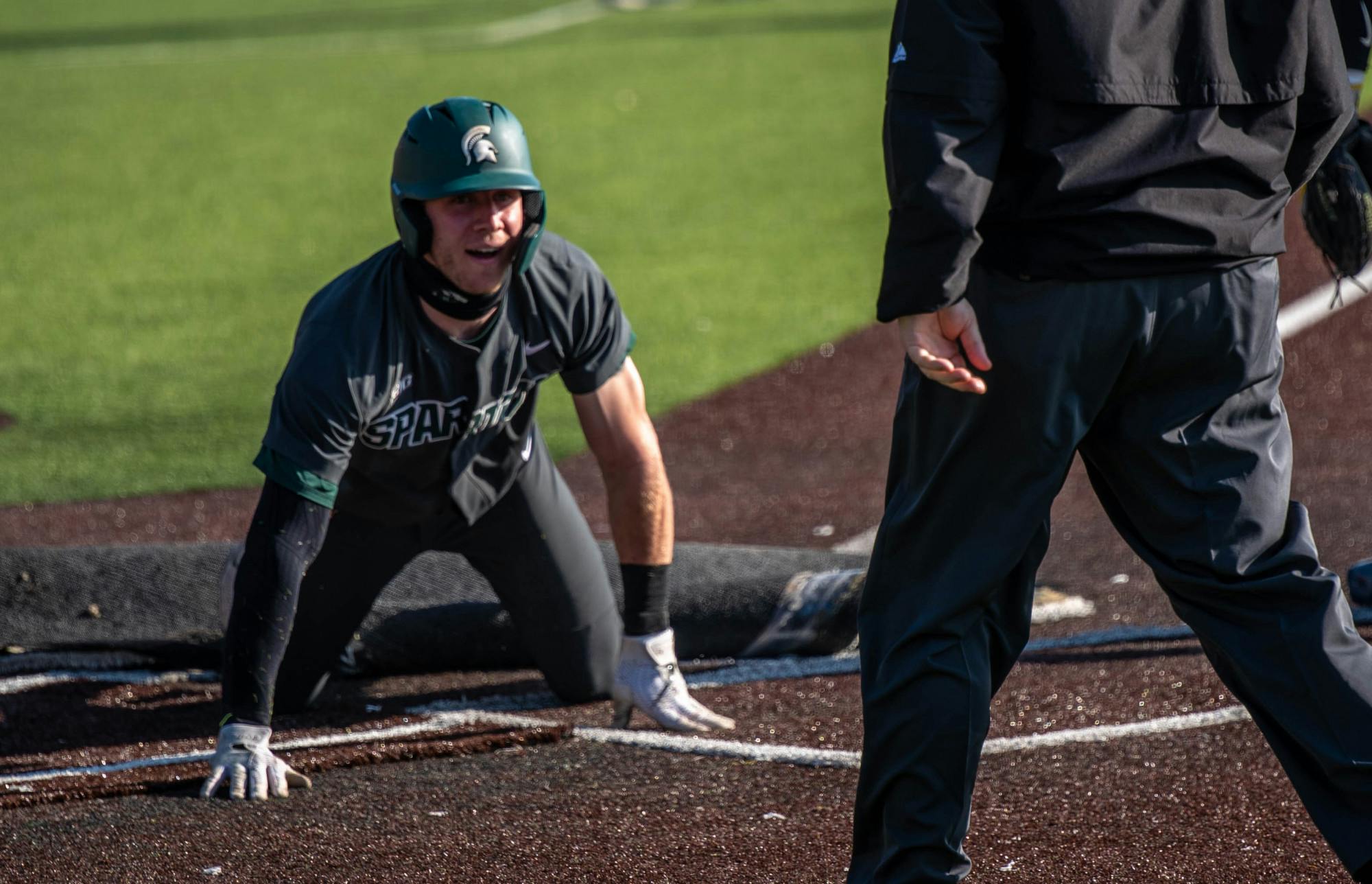 <p>Senior outfielder Joe Stewart (5) slides into home during the fourth inning. The Wolverines made a comeback in the ninth inning to top the Spartans, 8-7, at Ray Fisher Stadium on March 21, 2021.</p>