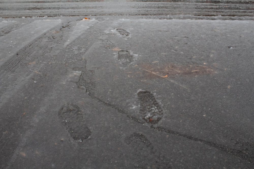 <p>Footprints are left behind after rain turns hail to slush in a parking lot in Abbott Pointe on Jan. 11.</p>