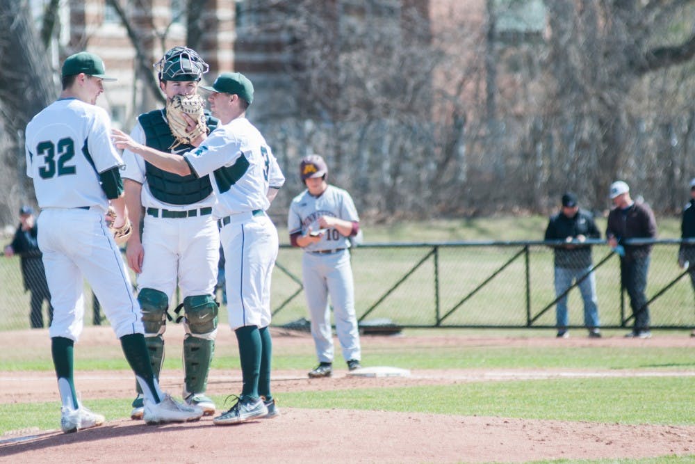 Teammates talk at the pitcher's mound during the game against the University of Minnesota on April 1, 2017 at McLane Stadium at Kobs Field. The Spartans were defeated by the Goldy Gophers, 3-2.