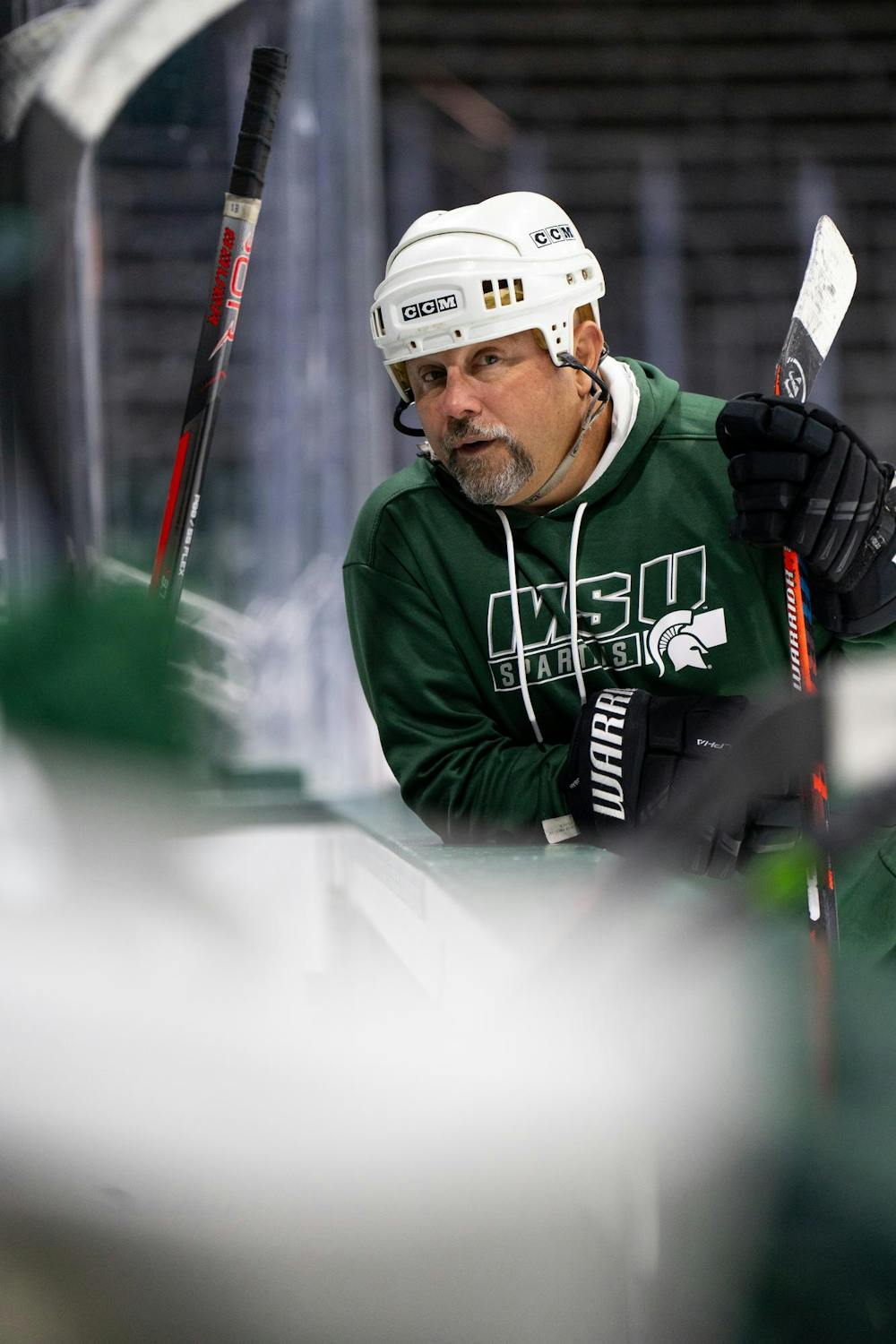 <p>Michigan State women's hockey assistant coach Tony Siciliano speaks to players at the bench during a team practice at Munn Ice Arena, Sept. 19, 2024.</p>