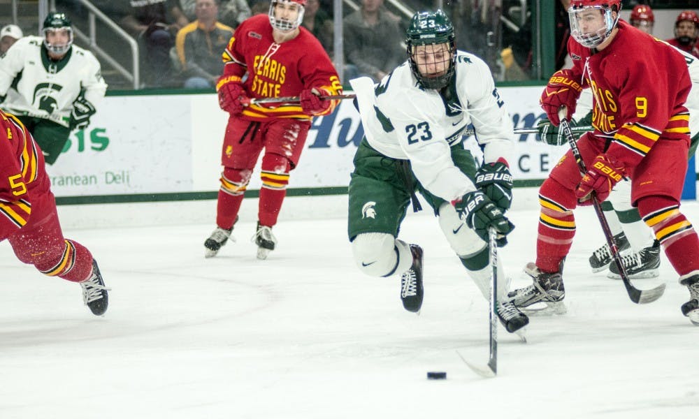 Junior forward Cody Milan (23) brings the puck up the ice during the game against Ferris State, on November 17, 2017, at Munn Ice Arena. The Spartans defeated the Bulldogs, 3-2.
