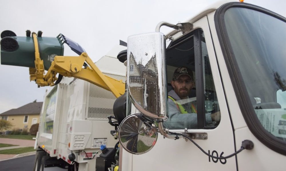 <p>East Lansing Department of Public Works worker Shaun O'Berry watches as trash is poured into his truck on Oct. 22, 2015 in East Lansing.&nbsp;<a href="http://statenews.com/staff/sundeep-dhanjal">Sundeep Dhanjal</a> | The State News</p>