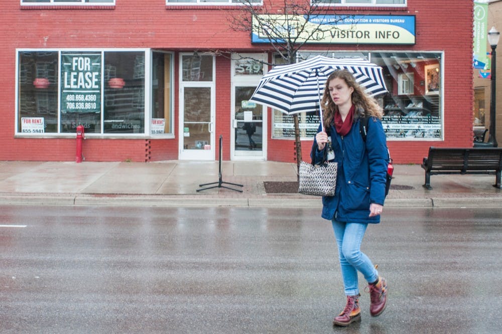 Environmental engineering junior Allison Lukens walks in front of the now-empty storefront of closed Sweet Lorraine's Fabulous Mac n' Cheez! on April 4, 2017 at 547 E. Grand River Ave. Lukens was walking to class. 