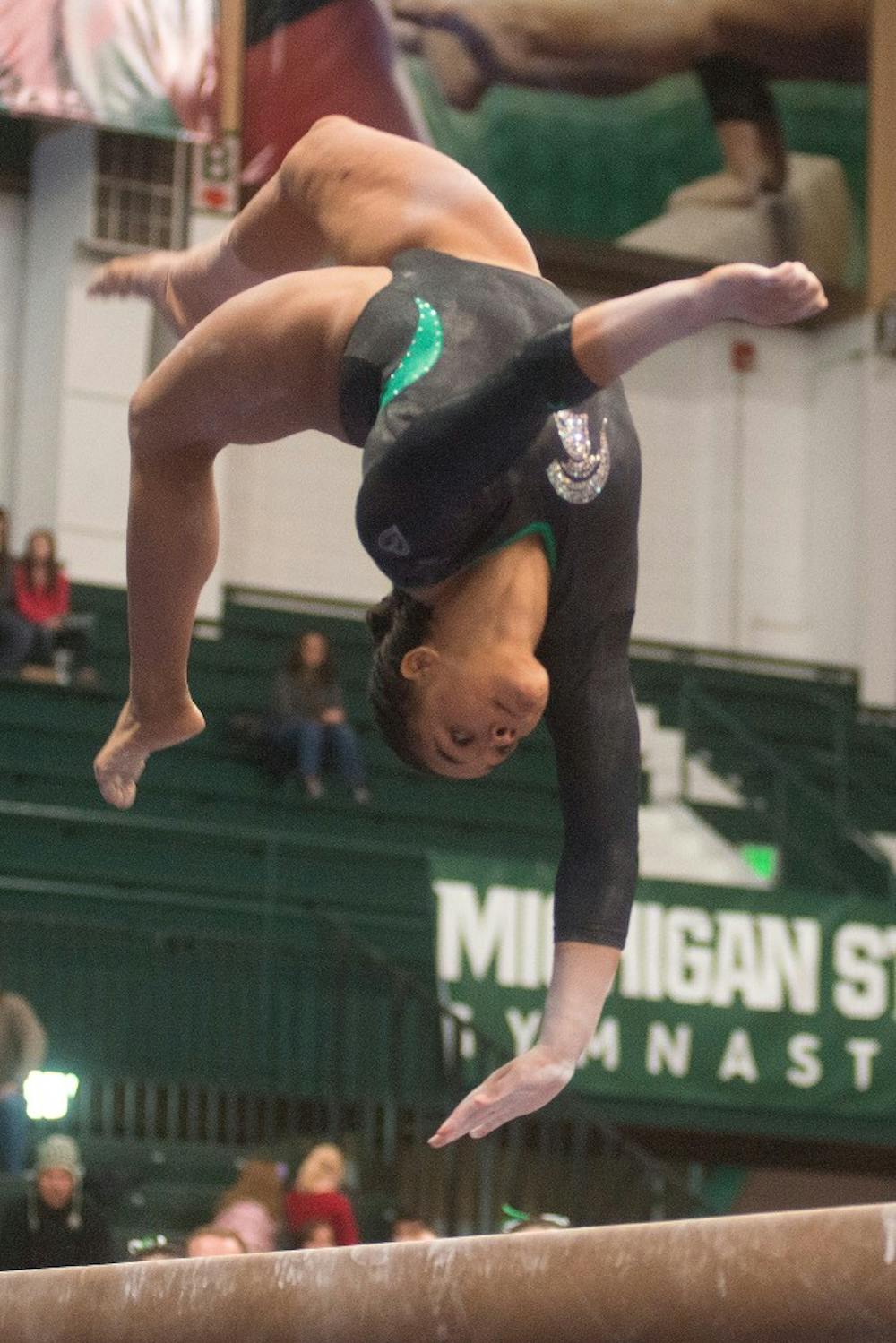 <p>Gymnast Alina Cartwright performs on the beam March 15, 2014, at Jenison Field House during the Big Ten Quad Meet against Nebraska, Illinois and Ohio State. The gymnastics team finished third with a 196.200, which was a team season-best. Julia Nagy/The State News</p>