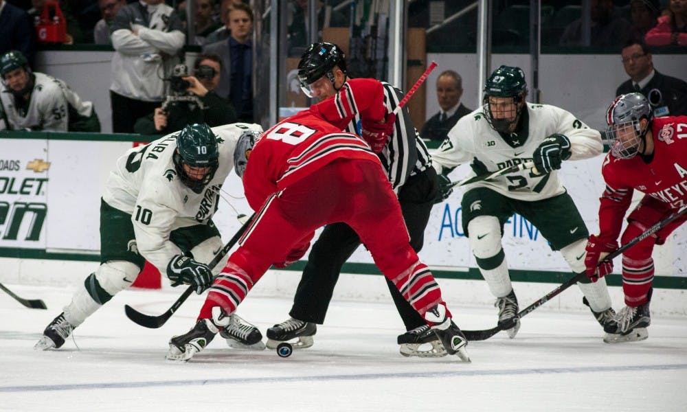 Freshman center Sam Saliba (10) fights for the puck with Ohio State center Dakota Joshua (8) during the game against Ohio State on Feb. 17, 2017 at Munn Arena. The Spartans were defeated by the buckeyes, 3-2.