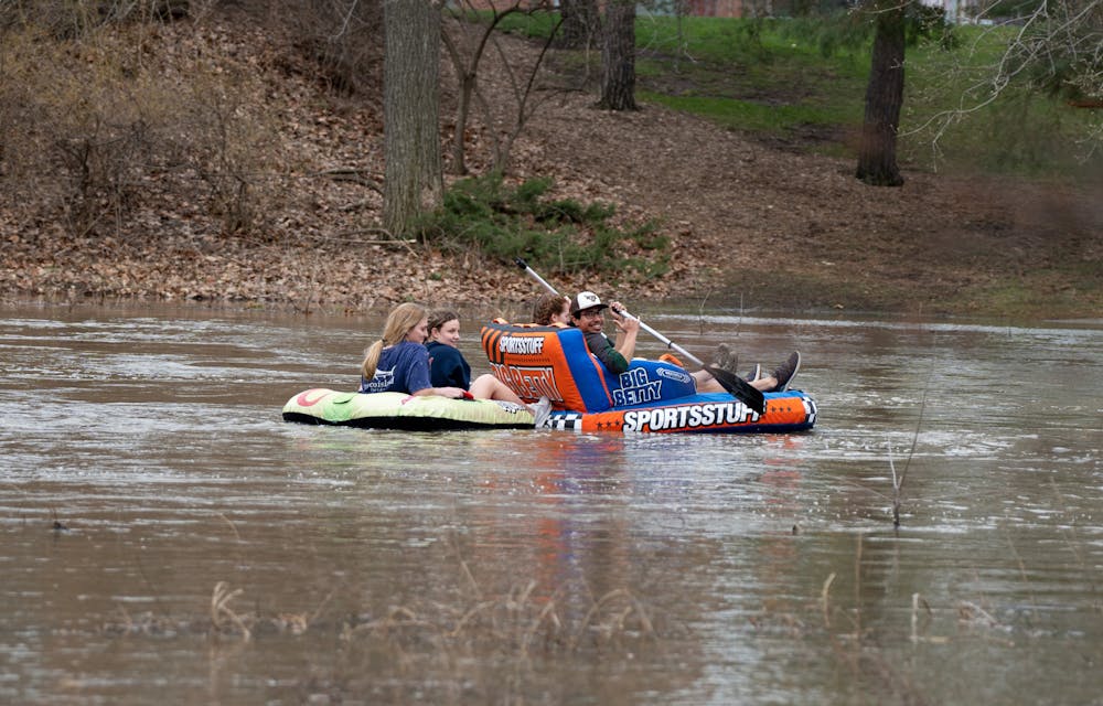 MSU students paddle through the Red Cedar River on a raft after heavy rainfall and flooding on campus on April 5, 2023. 