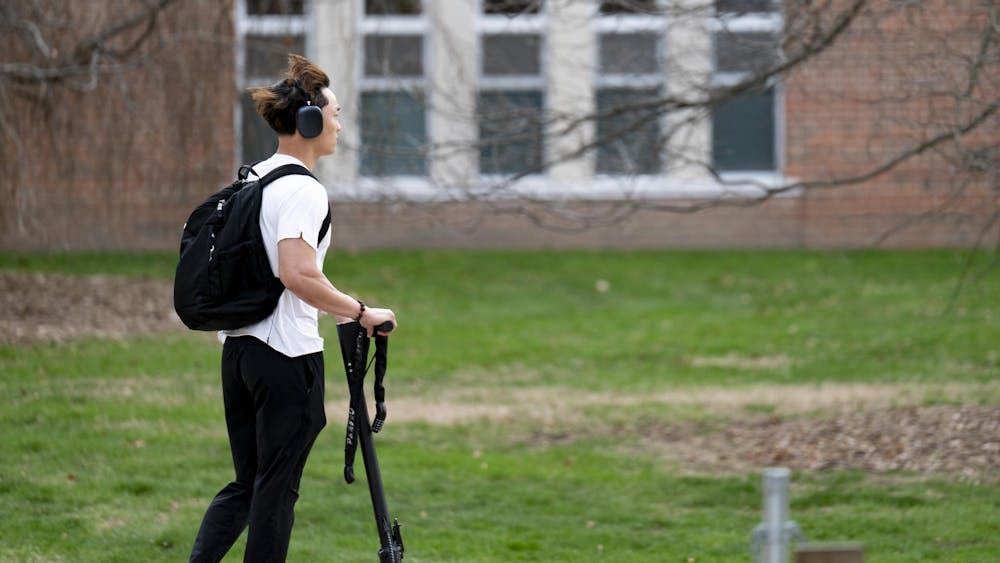 Student riding a scooter along the river trail at Michigan State University campus on April 14, 2025