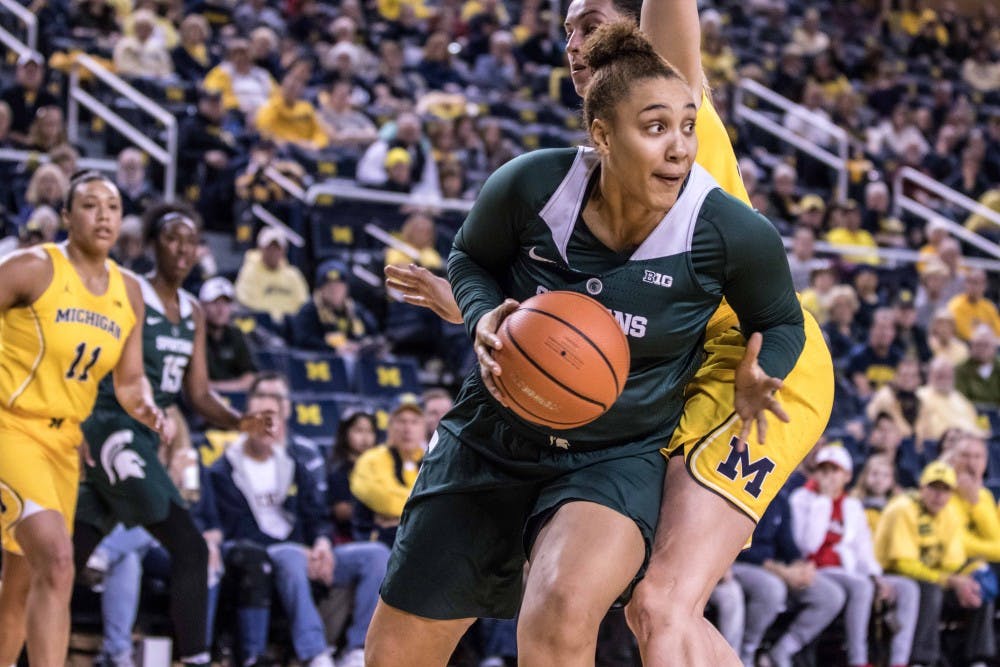 Senior forward Kennedy Johnson (55) passes around a defender during the game against Michigan on Jan. 23, 2018, at Crisler Center. The Spartans fell to the Wolverines, 74-48.