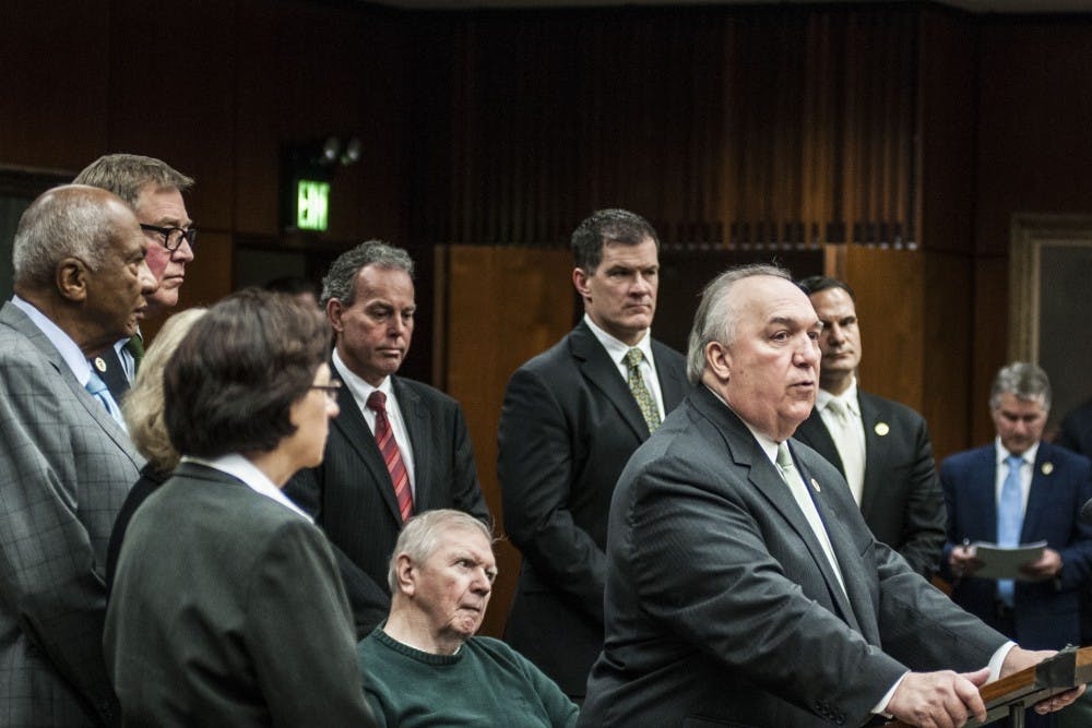 <p>Interim president John Engler addresses the media with the Board of Trustees backing him on Jan. 31, 2018, at Hannah Administration Building. (C.J. Weiss | The State News)</p>