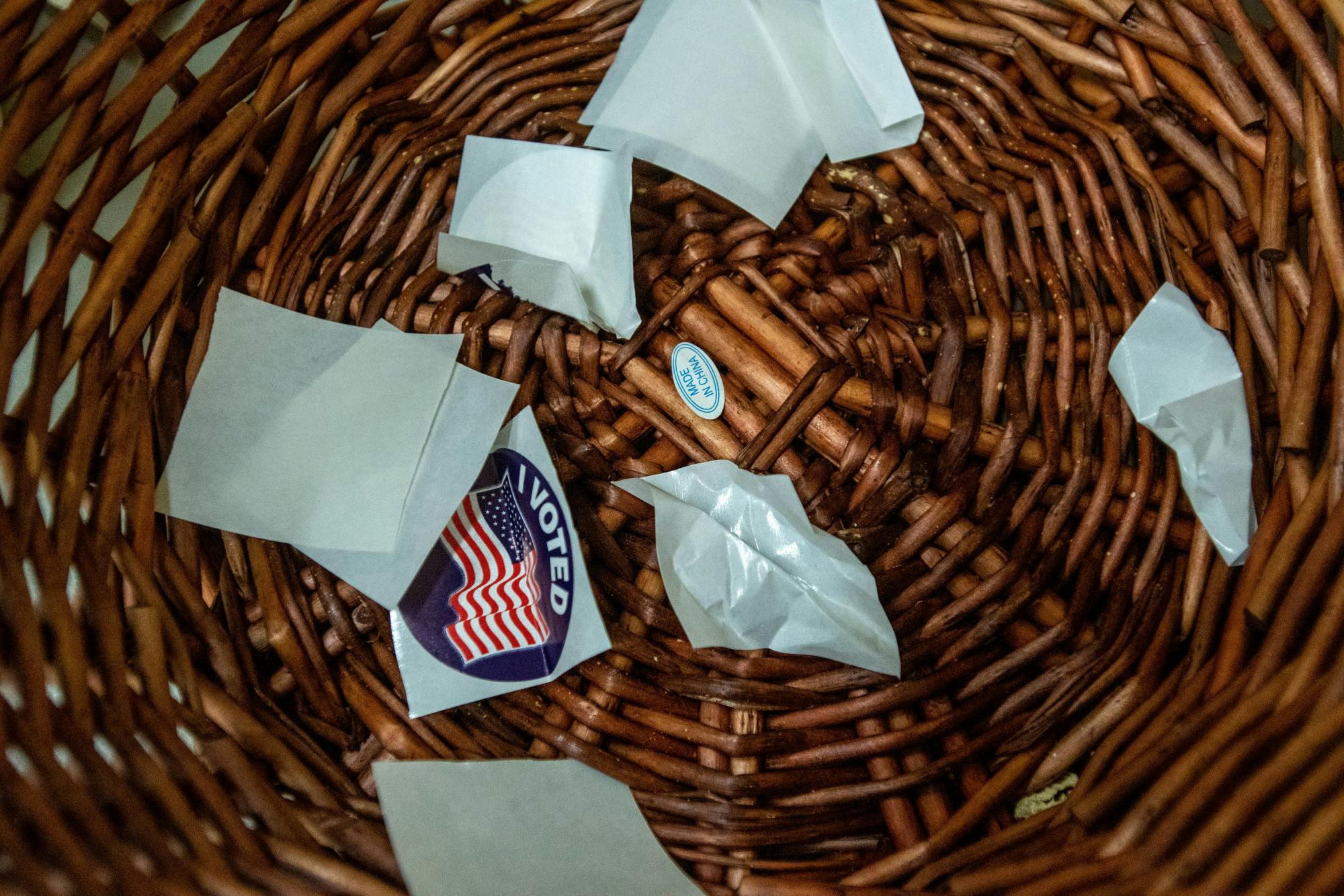 The backs of 'I voted' stickers in a waste basket.