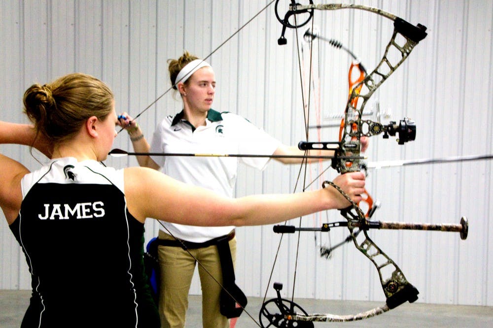 Animal science senior Maria James and human biology freshman Morgan Cannon line up to shoot targets Sunday afternoon at Demmer Center. Aaron Snyder/The State News. 