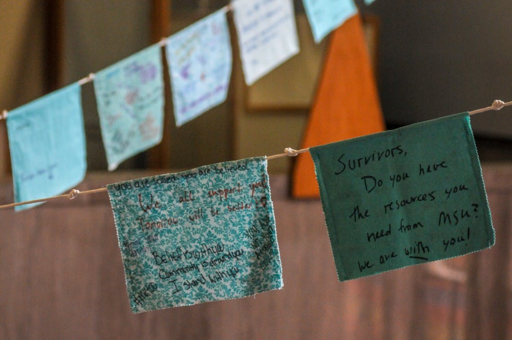 Prayer flags hang during the Finding Our Voice: Sister Survivors Speak Exhibition Opening Ceremony at the MSU Museum on April 16, 2019.