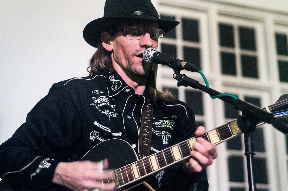 	<p>Joe Wilson, guitarist of The True Falsettos performs Sunday night, Jan. 13, 2013, at the Orchard Street Pump House, 368 Orchard Street. The Pump House gathers musicians across the nation to perform for small groups of East Lansing residents. Adam Toolin/The State News</p>