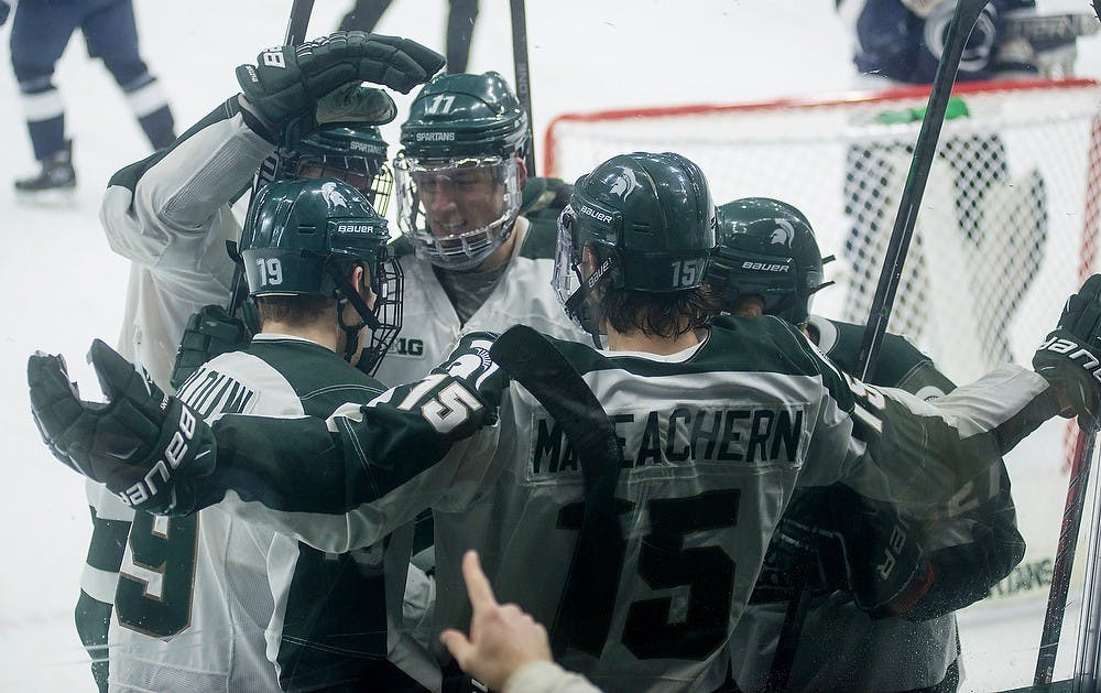<p>Sophomore shot Mackenzie MacEachern initiates a huddle on Feb. 14, 2015, in celebration of MSU scoring during the Michigan State hockey game against Penn State at Munn Ice Arena in East Lansing. The Nittany Lions were defeated by the Spartans 3-2. Emily Nagle/The State News</p>