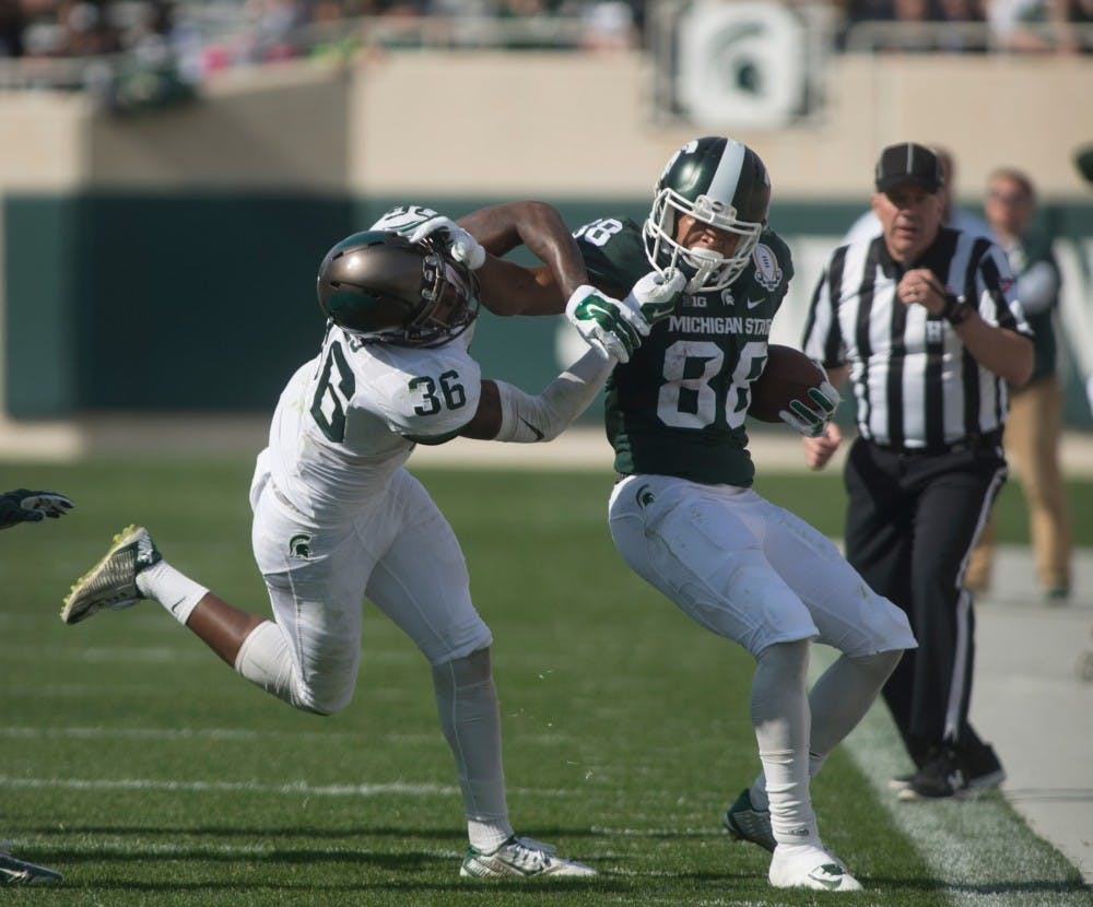 <p>Then-senior wide receiver Monty Madaris (88) stiff arms then-sophomore cornerback Kaleel Gaines (36) during the Green and White scrimmage on April 23, 2015 at Spartan Stadium. The White team defeated the Green team, 14-11.</p>