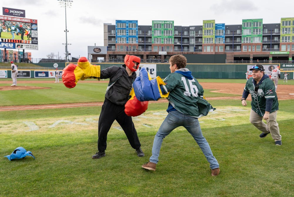 <p>Two fans fight to the death as part of between-innings entertainment during the "Crosstown Showdown" at Jackson Field in Lansing, MI on Wednesday, April 3, 2024. The night's wet weather didn't stop dedicated baseball fans from having a good time.</p>