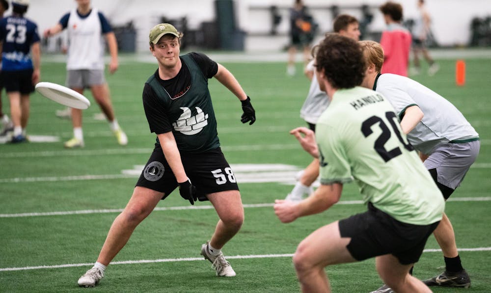 Political theory junior and ultimate frisbee player Sam Pierson makes a throw to his teammate during practice at the Tom Izzo Football Center on Feb 5, 2025.